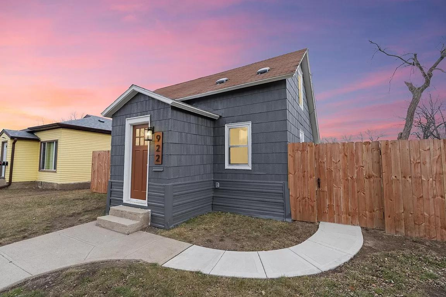 Charming Two-Story Home at 922 N Summit Ave, Sioux Falls Two-story home with gray siding and fenced backyard at dusk in Sioux Falls, SD