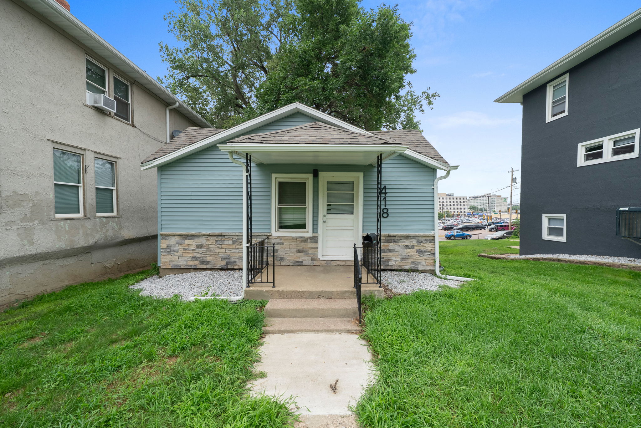 7-web-or-mls-DSC04057 A two-story residential home with blue siding and white trim, featuring a front porch and an attached single-car garage, located at 1409 S Norton Ave, Sioux Falls, SD.