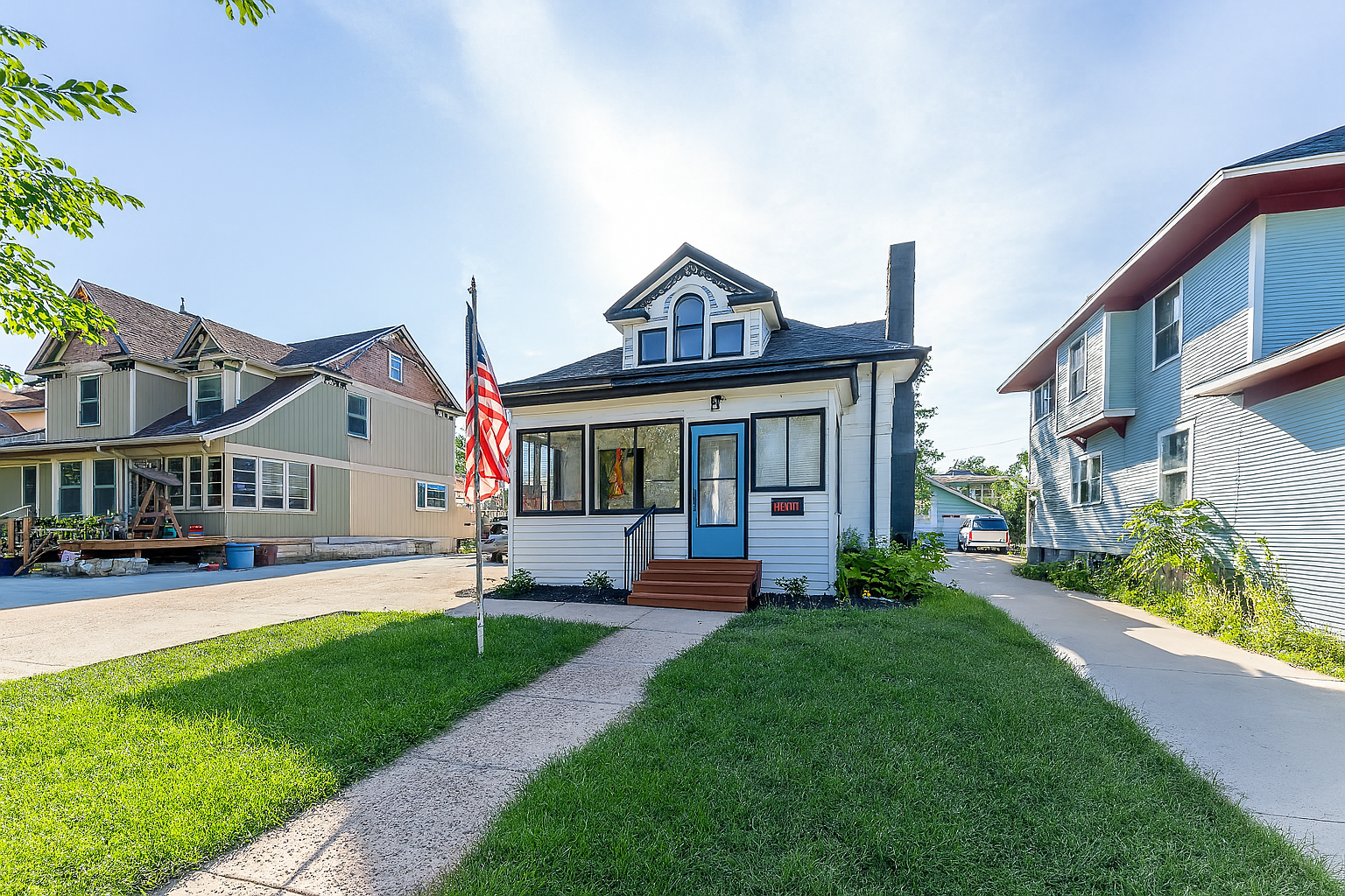 Cozy Cape Cod Home Surrounded by Greenery in Sioux Falls A quaint Cape Cod-style home with beige siding and white window frames, nestled among mature trees in a lush green lawn, located at 2201 S Euclid Ave, Sioux Falls, SD.