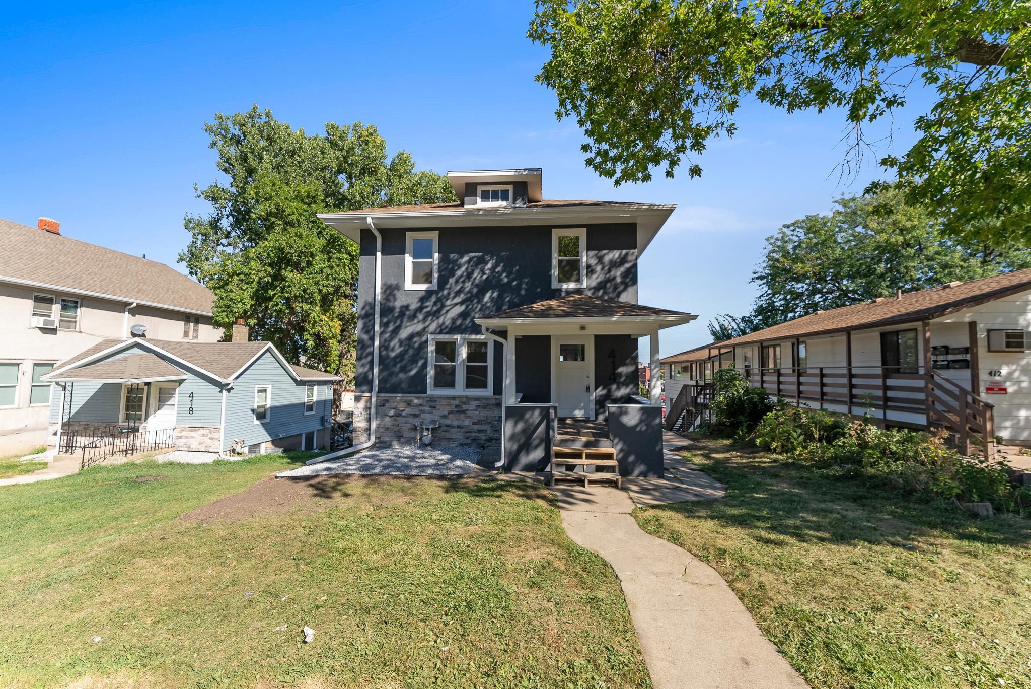 Cozy Cape Cod Home Surrounded by Greenery in Sioux Falls A quaint Cape Cod-style home with beige siding and white window frames, nestled among mature trees in a lush green lawn, located at 2201 S Euclid Ave, Sioux Falls, SD.